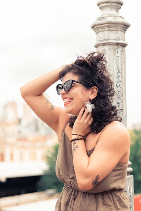 foto tirada em belo horizonte com a modelo de lado com sorriso largo e óculos escuro'