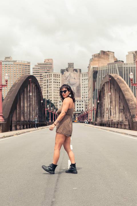 Viadulto Santa Tereza com a modelo no meio do viadulto em pé e de de lado, olhando por cima dos ombros.'