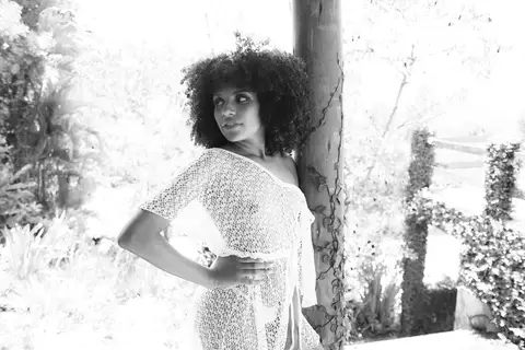 Ensaio sensual, foto em p/b, feita em um tronco com algumas folhas enroladas. '