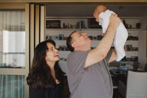 Fotografia de pai segurando o filho na sala '