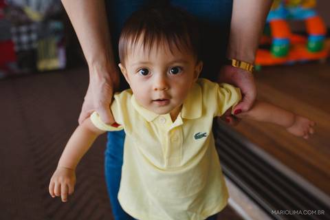 Fotografia de mãe segurando bebê pelo braço'
