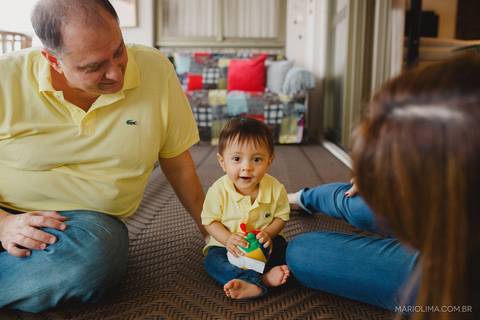 Retrato de bebê brincando com os pais na sala'