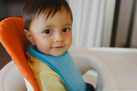 Fotografia de criança na cadeira de comer'
