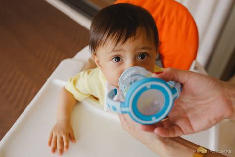 Retrato de bebê tomando suco no copo'