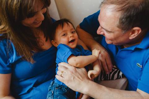 Retrato de pais no sofá segurando bebê'