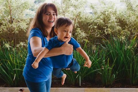 Retrato de mãe fazendo aviãozinho no filho'