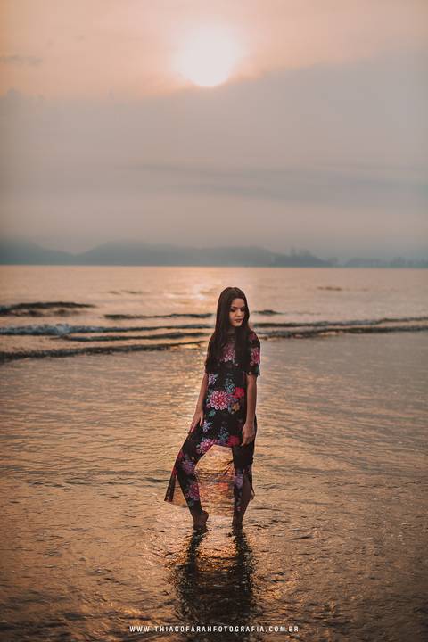 ensaio externo em santos, 15 anos, praia, por do sol, nuvens, vestido florido, mar, beira de água'