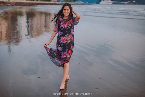 ensaio externo em santos, 15 anos, praia, por do sol, nuvens, vestido florido, mar, beira de água, andando'