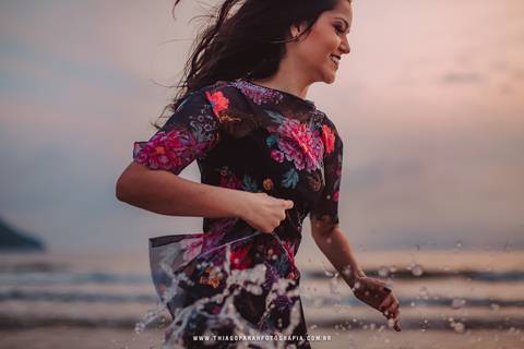 ensaio externo em santos, 15 anos, praia, por do sol, nuvens, vestido florido, mar, beira de água, correndo'