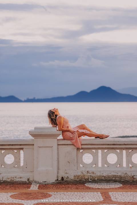Sentada na mureta de santos ao por do sol'