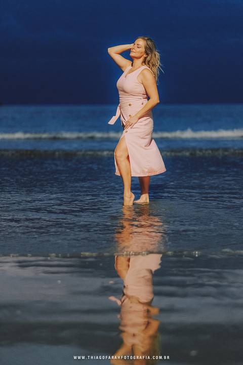 Pose na beira da água ceu azul,  vestido rosa claro, ponta da praia em santos'