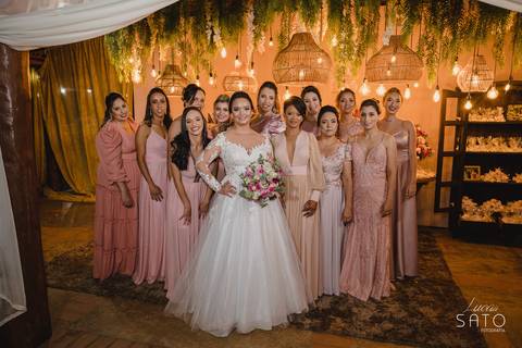 Foto da madrinhas com vestidos no tom  de cor rosa.'