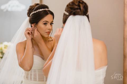 Foto que não pode faltar na produção da noiva. Noiva colocando o brinco no salão de beleza.'