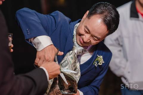 Foto de gravata durante a Recepção de Casamento da Camila e Thiago no Sítio Águas de Março em São Gotardo-MG.'
