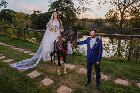 Noiva e noivo com cavalo durante o Casamento realizado no Sítio Águas de Março em São Gotardo'