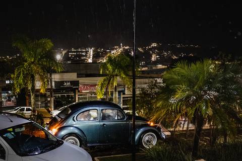 Noiva chegando na Igreja no belo fusca sob as chuvas de novembro. Foto de Lucas Sato fotógrafo profissional de Casamentos de São Gotardo e região.'