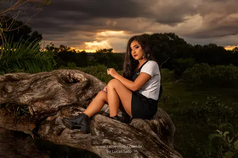 Vestido florido para ensaio externo feminino realizado no município de São Gotardo-MG. Ensaio de 15 anos, book externo em área verde, natureza. Foto com estilo strobist, uso de flashes.'