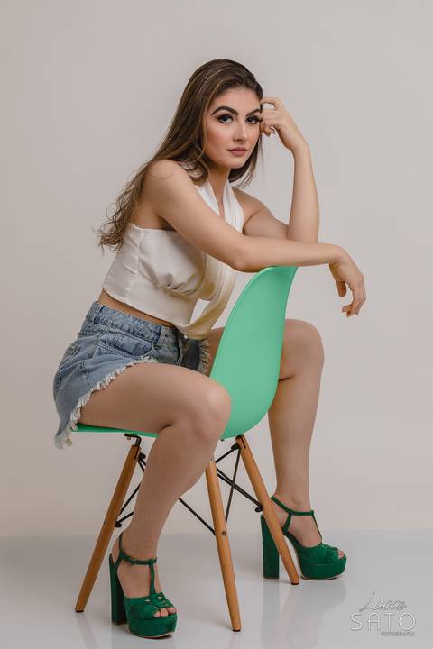 Pose feminina para ensaio com cadeira.'