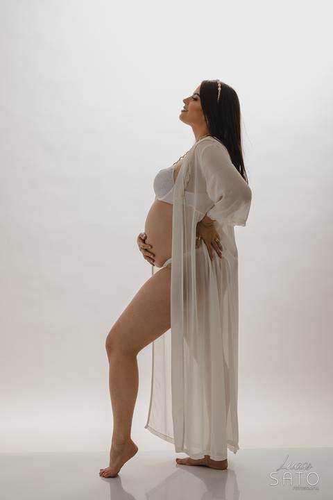Vestido de gestante para ensaio fotográfico em estúdio.'