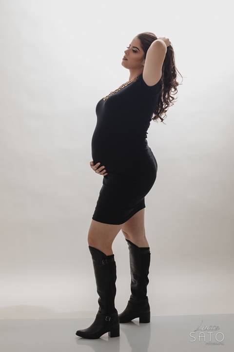 Pose para ensaio de gestante em estúdio fotográfico.'