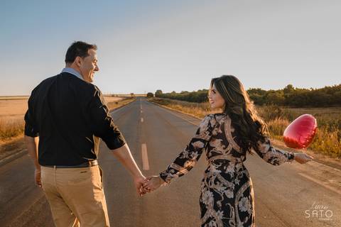Ensaio de casal no asfalto perto de São Gotardo e rodeado de trigos.'