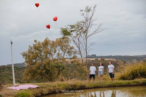 Ensaio de família com balão de coração.'