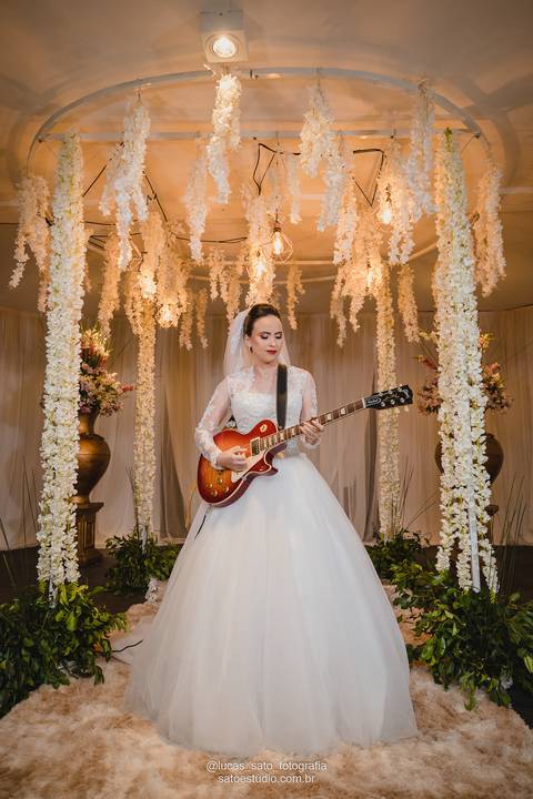 Noiva tocando guitarra durante o casamento realizado em São Gotardo-MG, pelo fotógrafo profissional Lucas Sato-Fotografia.'