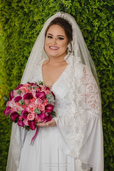 Vestido de noiva tradicional com buquê de rosas marsala e vermelhas combinando com a decoração da Recepção de casamento em São Gotardo-MG.'