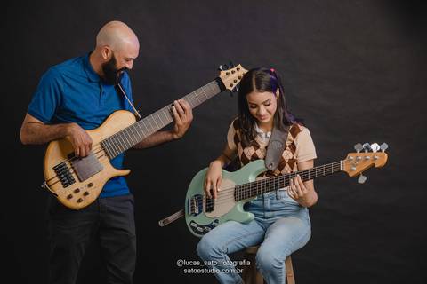 Ensaio 15 anos com tema música, tal pai e tal filha tocando baixo durante o ensaio fotográfico de 15 anos no Estúdio em São Gotardo-MG.'
