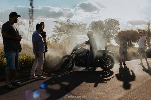 harley davidson com os padrinhos fritando pneu no making of do noivo com capacete de caveira totalmente criativo no dia do casamento thais augusto fotografa de casamento registra momentos criativos e especiais para os noivos no making of'