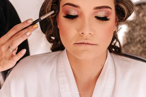 Noiva finalizando o maquiagem para o casamento'