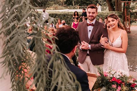 Noiva sorrindo ao lado do noivo no altar'