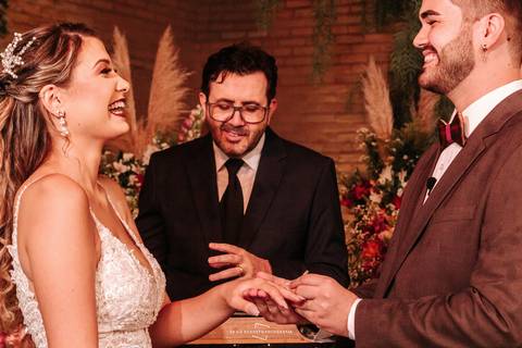 Noivos colocando as alianças um no outro'