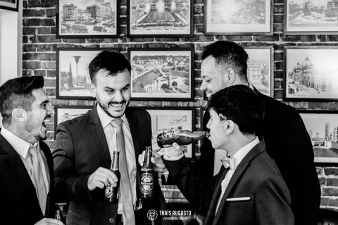 Retratos do noivo brindando com padrinhos'