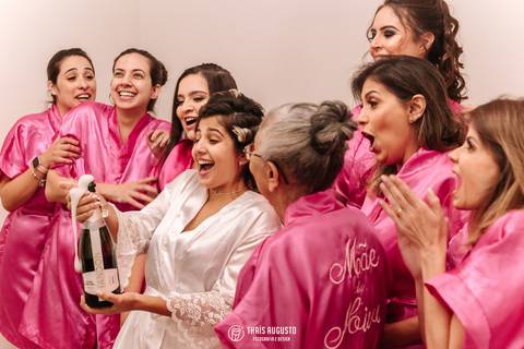 Retratos da noiva brindando com madrinhas espumante explodindo'