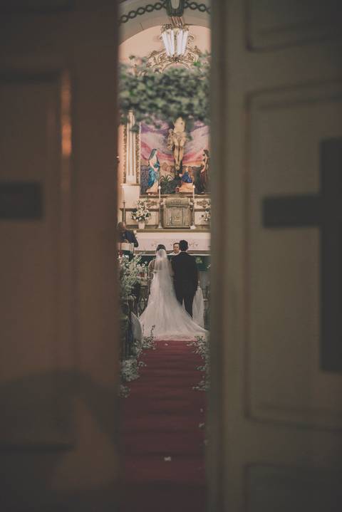 Noivos pela brecha  da porta da igreja'