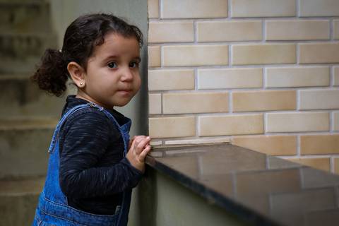 criança observa pelo mureta'