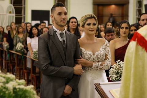 Noivos prestam atenção nas palavras ditas pelo padre, durante celebração de seu casamento'