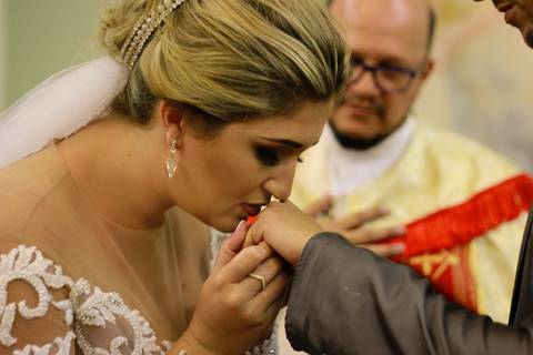 detalhe da noiva beijando aliança do noivo, após coloca-la em seu dedo'