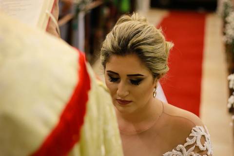 detalhe da noiva, de olhos fechados, sendo abençoada pelo padre'