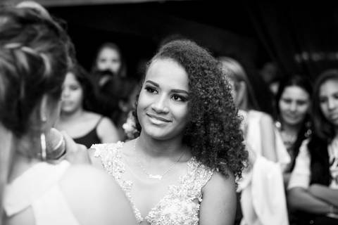 foto em preto e branco. Close da aniversariante, durante depoimento da mãe, na pista de dança'