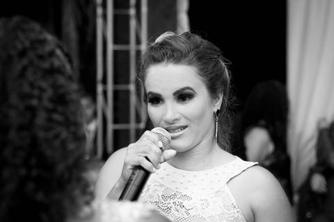 foto em preto e branco. Close da mãe da aniversariante, durante seu depoimento, na pista de dança'