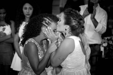 foto em preto e branco, mãe beija testa da filha, emocionada, após receber homenagem, na pista de dança'