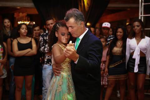 aniversariante dança a valsa com com o padrinho. Close do rosto dos dois'