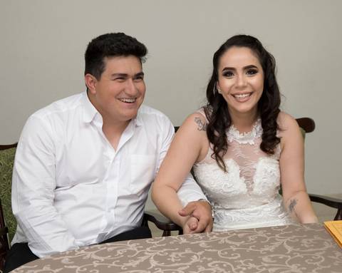 noivos felizes, rindo, de mãos dadas, durante cerimônia'