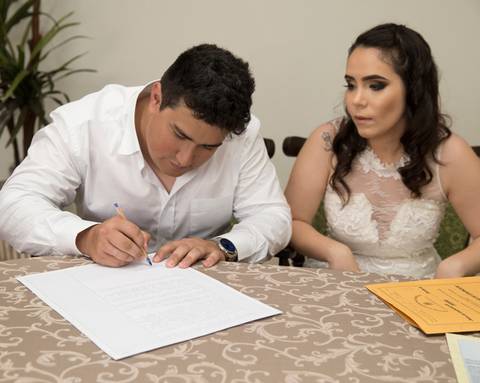 noivo assina certidão de casamento'