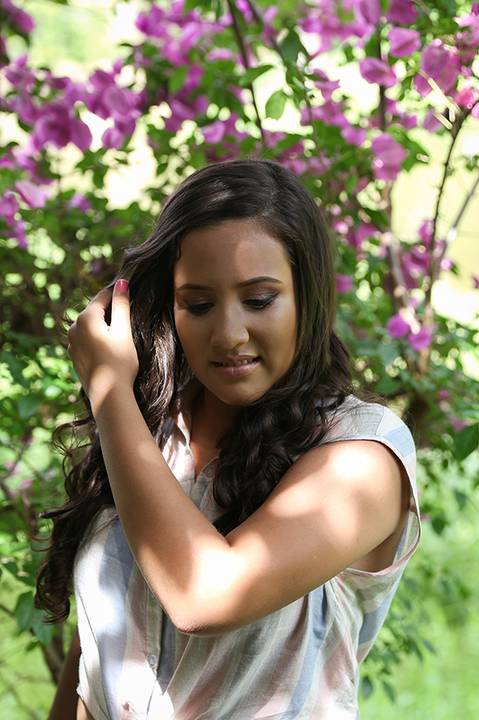 Debutante mexe nos cabelos, em meio as flores'