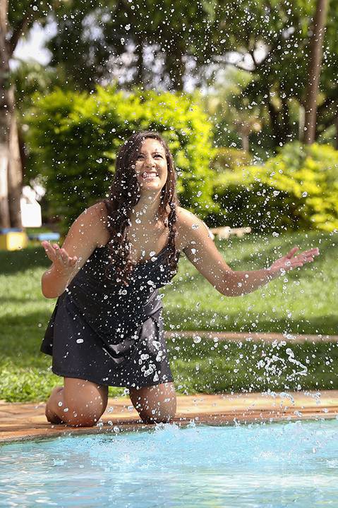 Debutante brinca jogando água para cima na piscina do clube'
