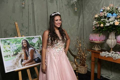 Debutante posa com seu segundo vestido, na decoração de entrada'