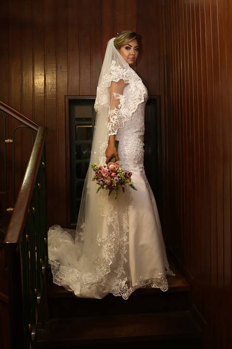 Noiva posa, antes de partir para igreja São Domingos, mostrando seu vestido, véu e bouquet'